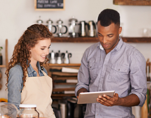 Employees in coffee shop looking at tablet